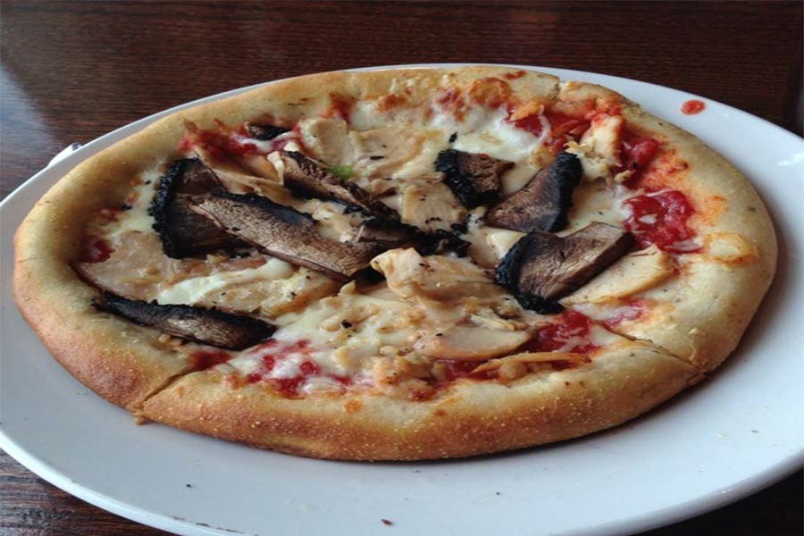This is a personal pizza with mushrooms and chicken.