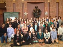 Students pose for group photo in front of the massive statue of famous playwright, William Shakespeare, in the lobby of the theatre.