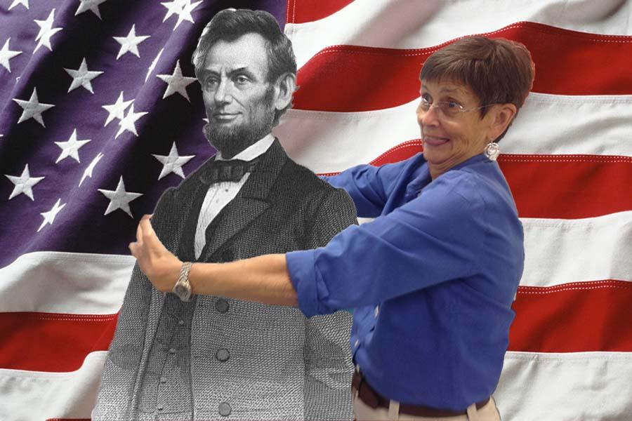 Mrs. Newell hugging Abraham Lincoln in front of the American flag