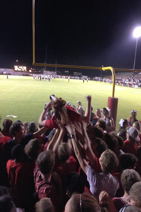 Student crowd surfing with horse head