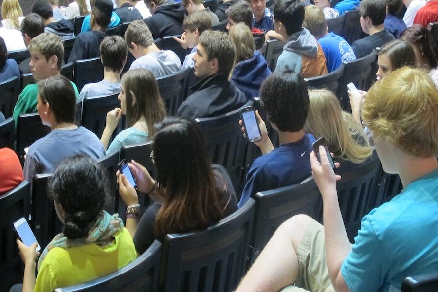 Students vote for SGA on their phones during the assembly.