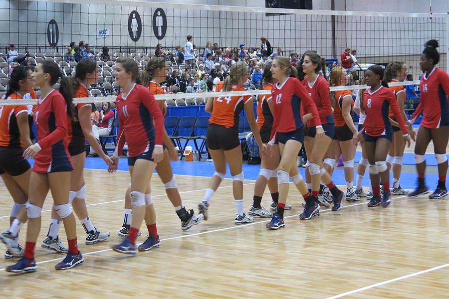 The team shakes hands with the Grissom players before the beginning of their match.