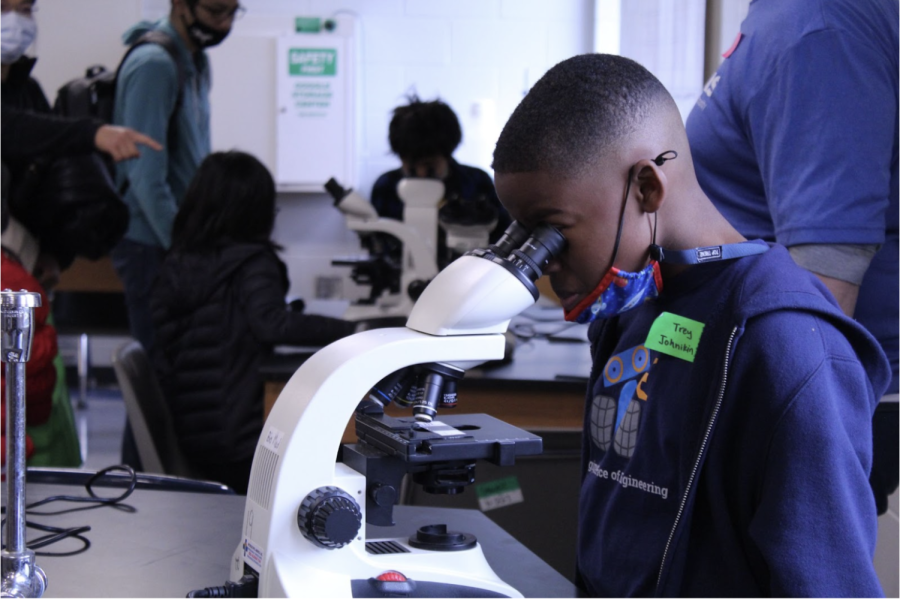 A 4th grader from Heritage looks through a microscope with curiosity. This is the first time kids were able to participate in this event virtually. Kathryn Teare said that she hopes that the in-person event will be more effective because the kids ”can ask questions and do hands-on activities.”