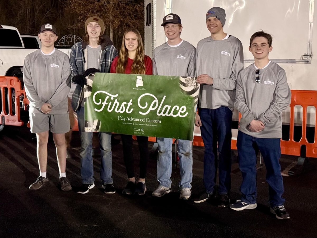 Patriot Racing's White team holding up a 1st place banner.